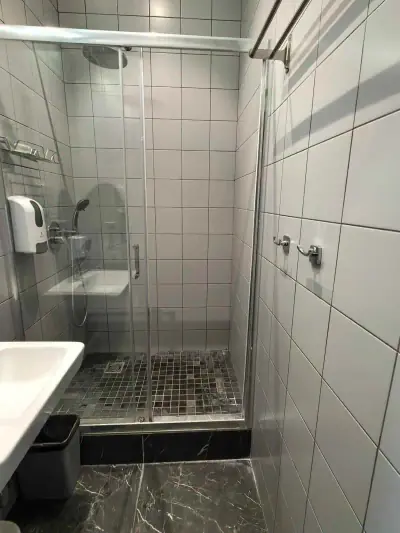 Cabina de ducha puerta cristal suelo mosaico azulejos blancos hotel cápsula GettSleep Aeroexpress Sheremetyevo