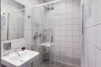 Baño ducha azulejos blancos lavabo espejo hotel cápsula GettSleep Aeroexpress Sheremetyevo