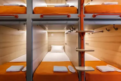 GettSleep Aeroexpress酒店单人下铺胶囊舱正面视图橙色床品拖鞋