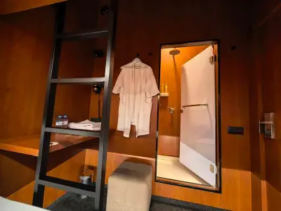 Cama inferior cupé GettSleep iluminación LED naranja escalera techo oscuro madera Terminal C