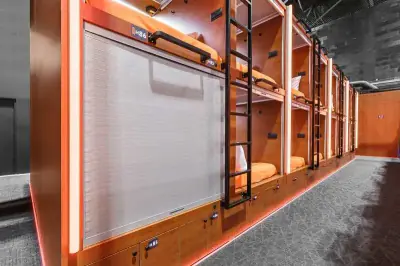 Pasillo cápsulas dobles GettSleep iluminación LED ambiente naranja cálida Terminal C