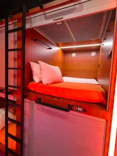 Interior cápsula superior pod doble GettSleep ropa naranja tira LED paneles madera Terminal C