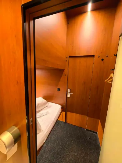 Vista interior completa minihabitación inferior Yin-Yang GettSleep cama escalera puerta baño privado Terminal C