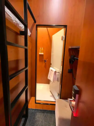 Vista amplia interior madera cápsula superior Yin-Yang GettSleep ropa naranja baño privado Terminal C